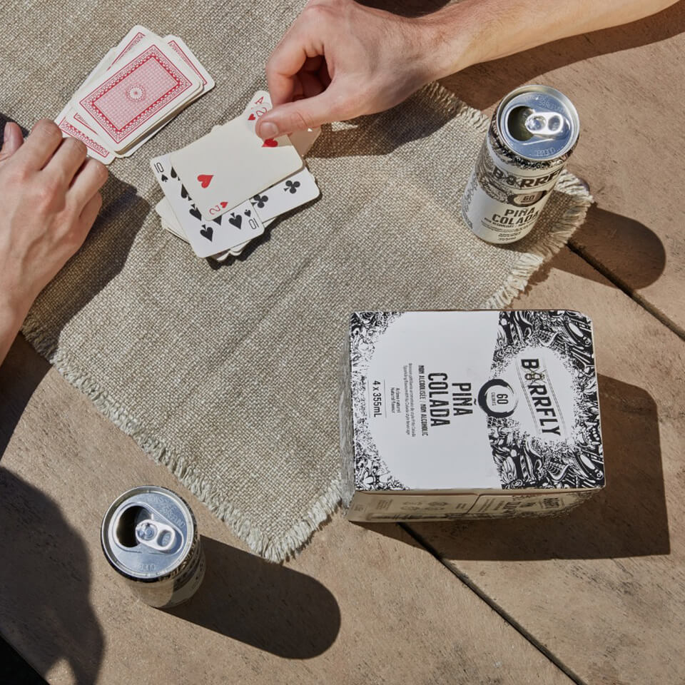 People playing cards with a white box and cans