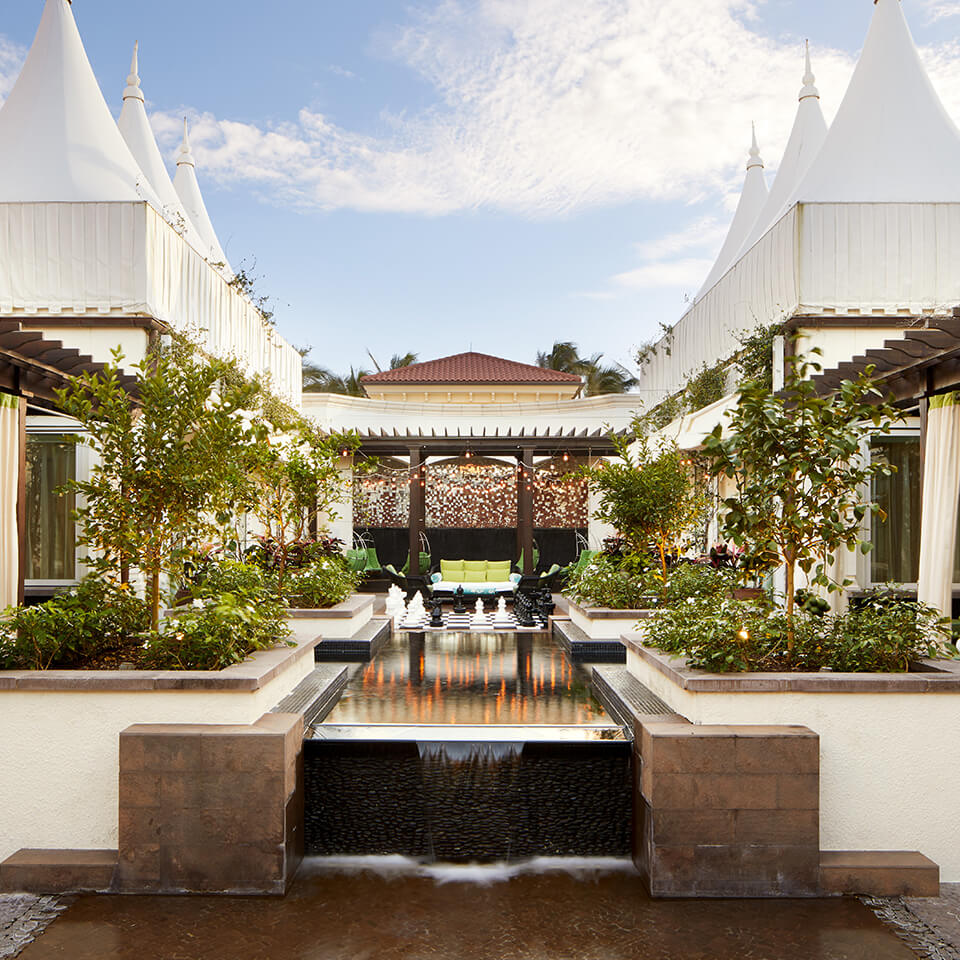 A spa garden with white tent tops and pools