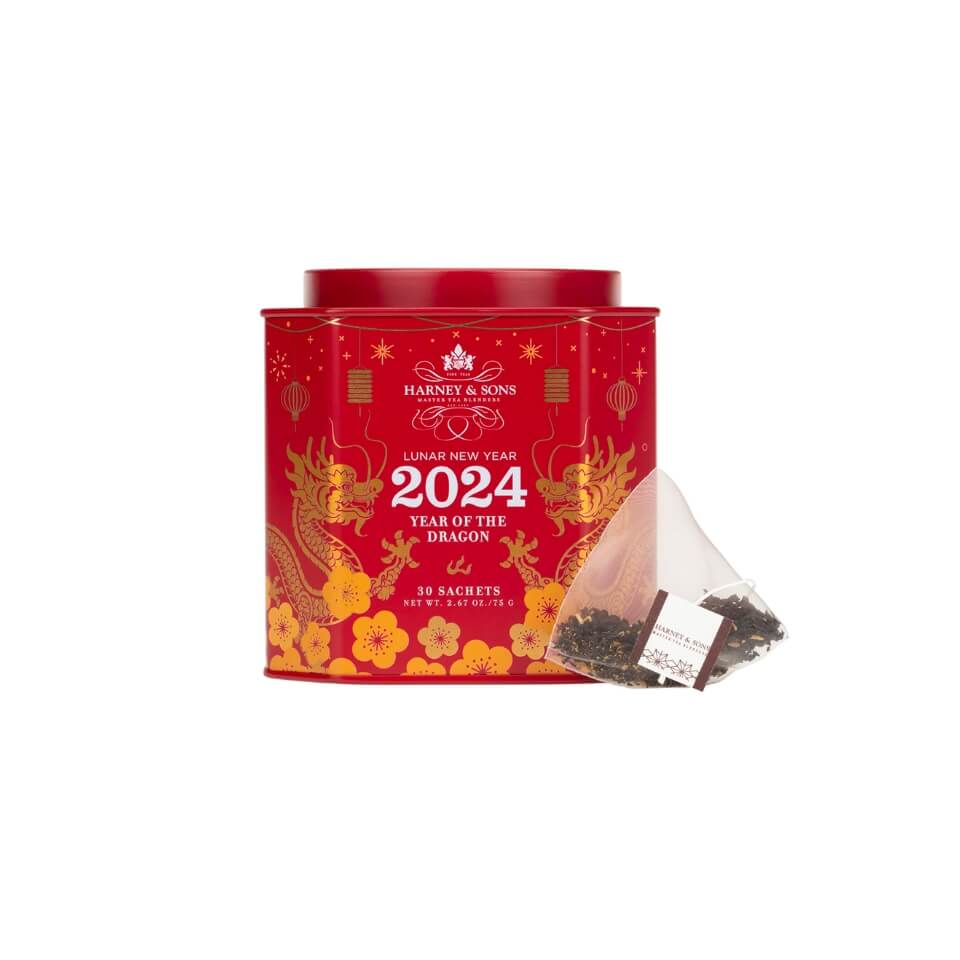 A red and gold canister with a tea bag next to it