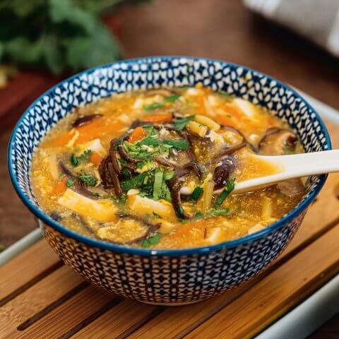 A blue bowl with hot and sour soup