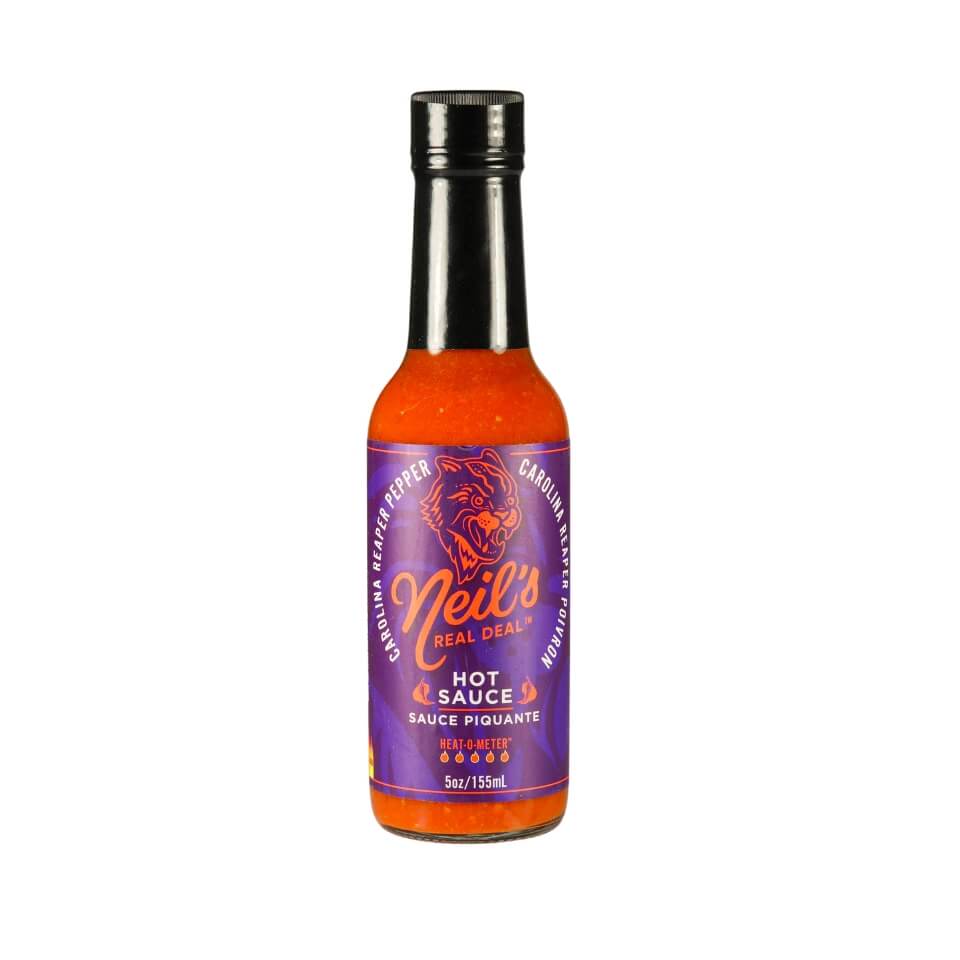 A bottle of red hot sauce with a black cap and purple label