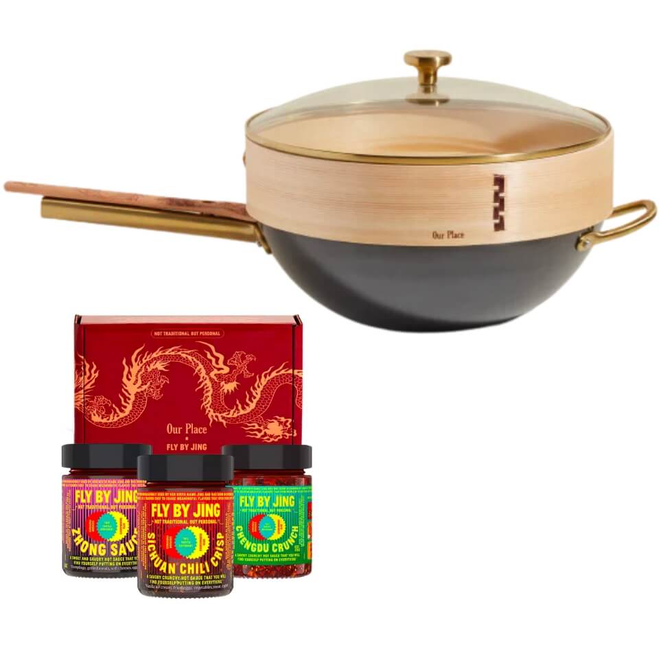 A wok with wooden accessories, three canisters of sauce and a red gift box