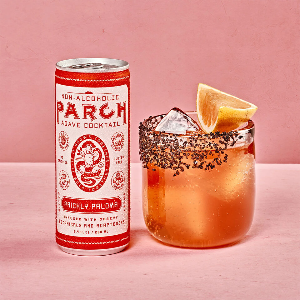 A pink and red can and a rimmed cocktail in front of a pink background