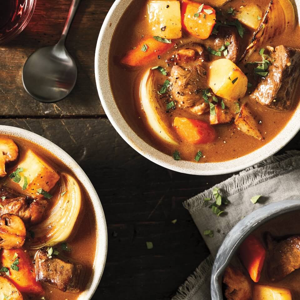 Bowls of beef stew with mushrooms, carrots and potatoes