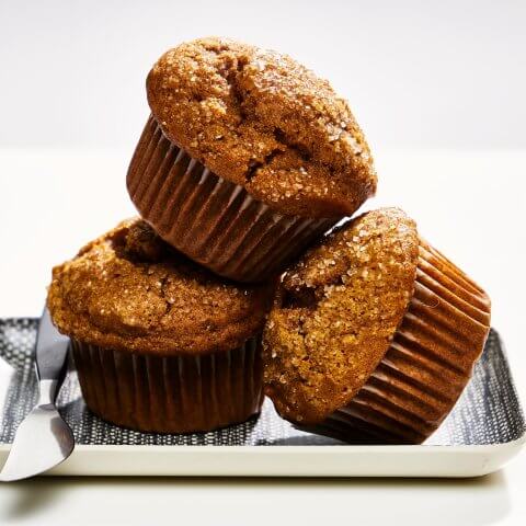 Three pumpkin muffins with brown paper