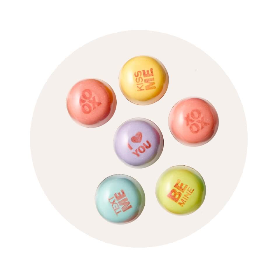 An assortment of multicoloured chocolates in a cream-coloured circle