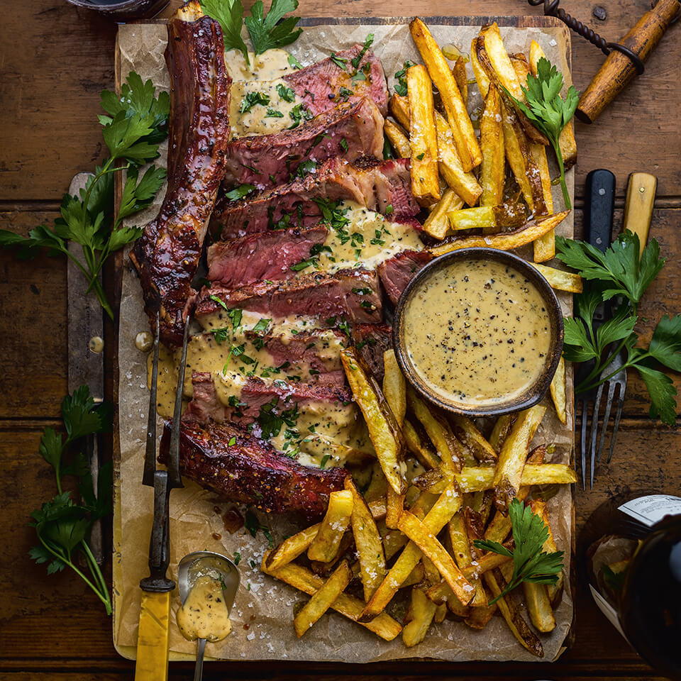 A board with steak frites and a steak knife