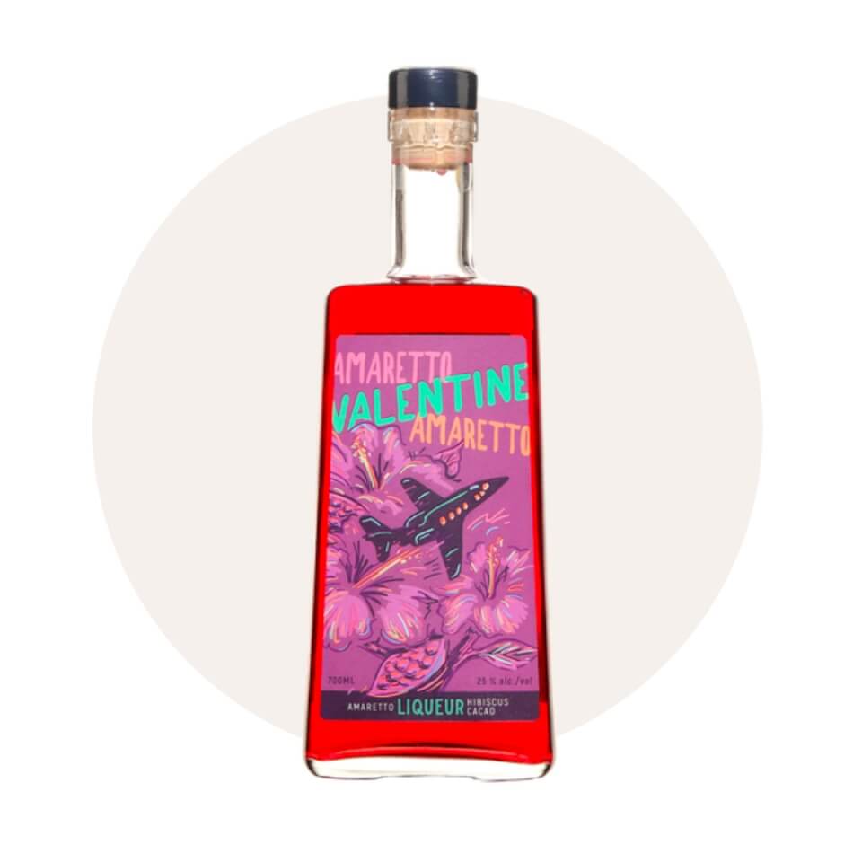 A bottle of bright red liqueur with a purple label over a cream-coloured circle