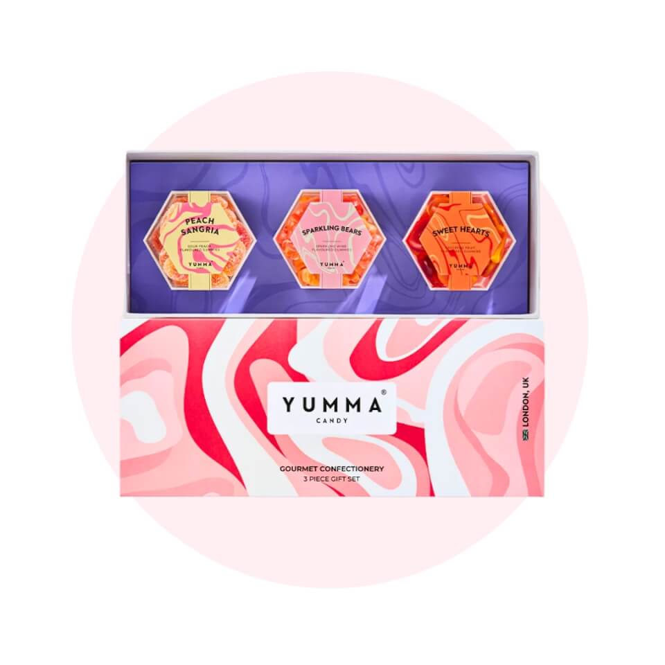 A box with three containers of candy over a light pink circle