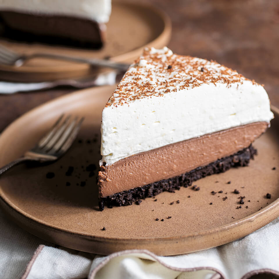 A slice of chocolate cream pie on a brown plate