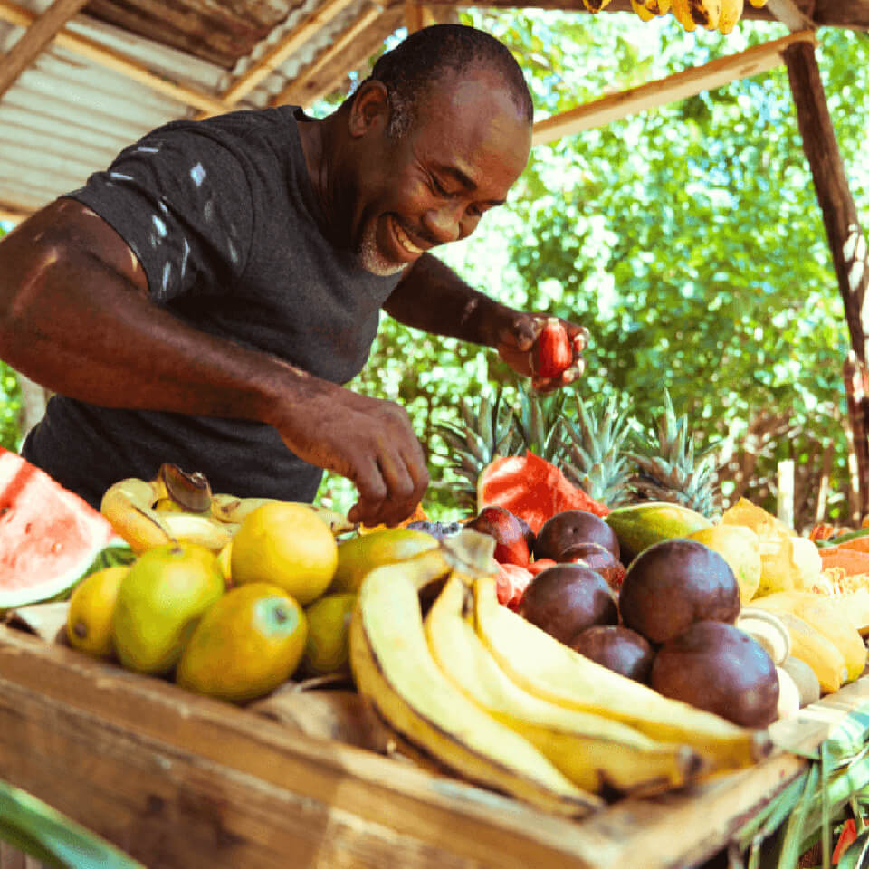 man serving fruit at fruitstand