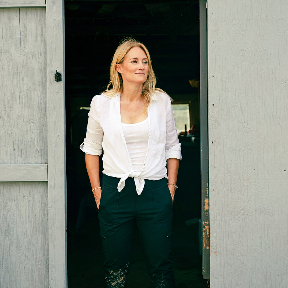 A woman, Kelly Mason, standing in a wooden doorway