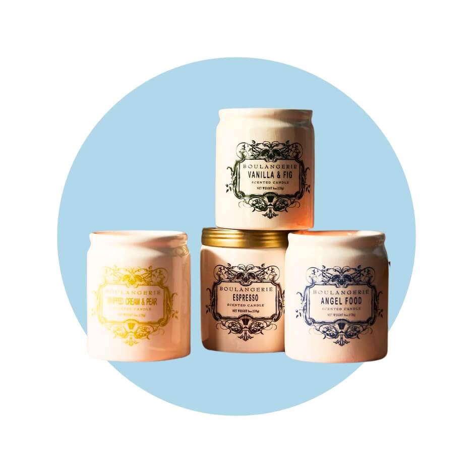 Four jar candles with logos in different colours over a light blue circle