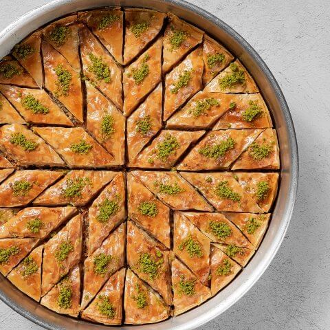 A circular dish with baklava cut in a geometric pattern