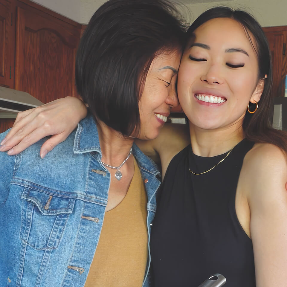 Two women embracing in a kitchen
