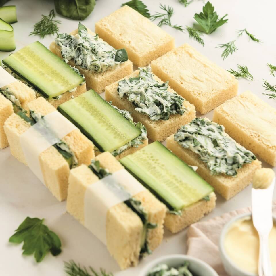 Cucumber tea sandwiches in various stages of assembly