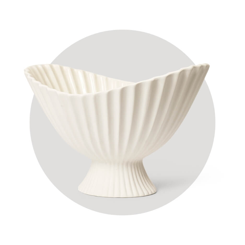 A white bowl with pedestal base and large lipped lid over a light grey circle