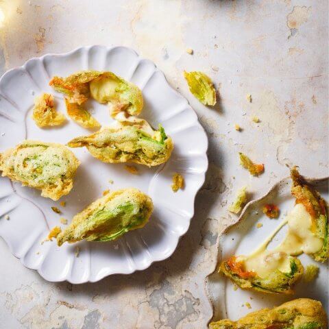 A white plate with fried zucchini flowers