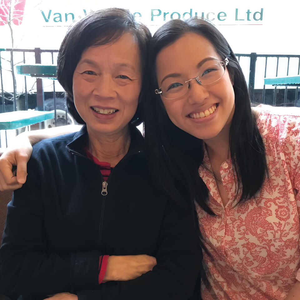 Two women smiling and posing together on an outdoor patio
