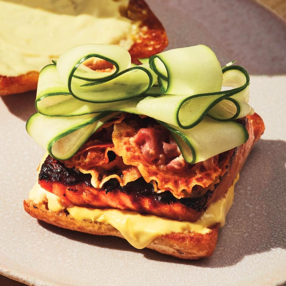 A sandwich with salmon, pancetta and cucumber ribbons