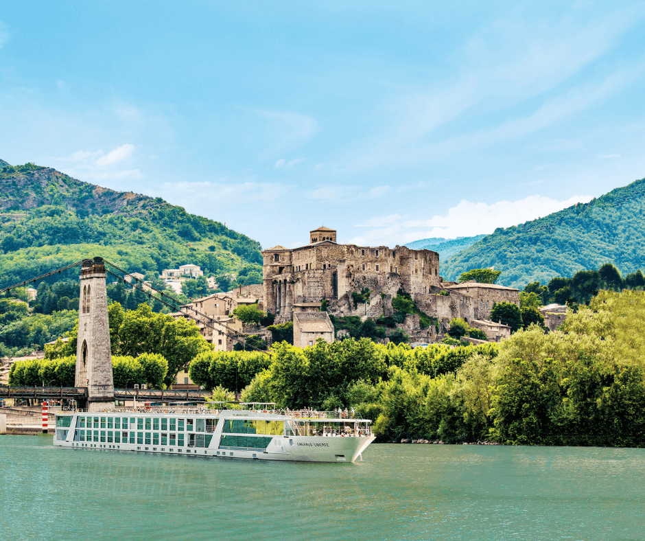 river boat in front of historic architecture and rolling hills