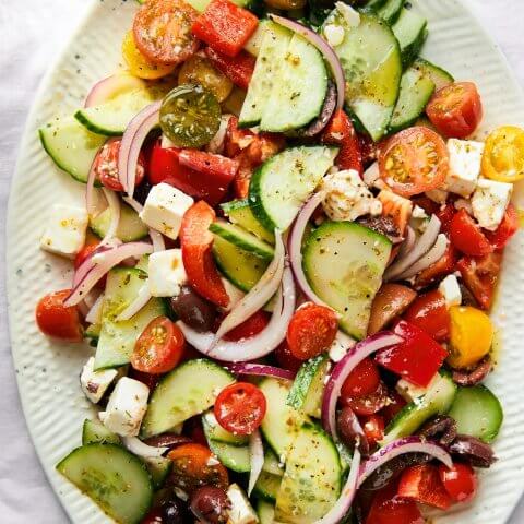 A white plate with a Greek salad