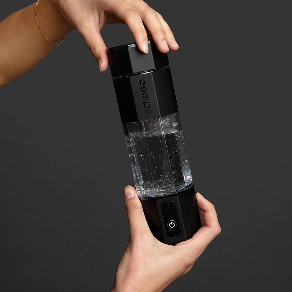 A person's hands holding a black water bottle