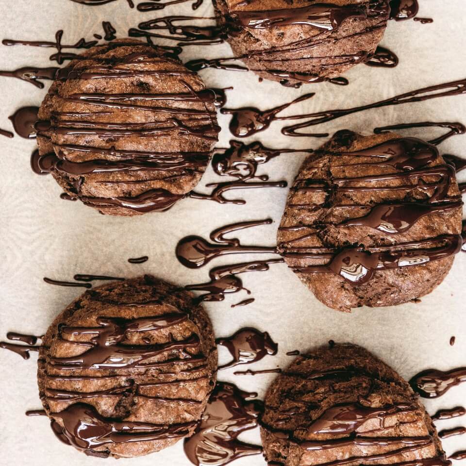 Chocolate scones on parchment paper drizzled with chocolate