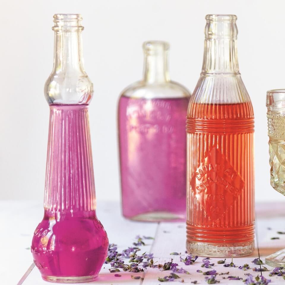 Clear glass bottles with different colours of cocktail syrup