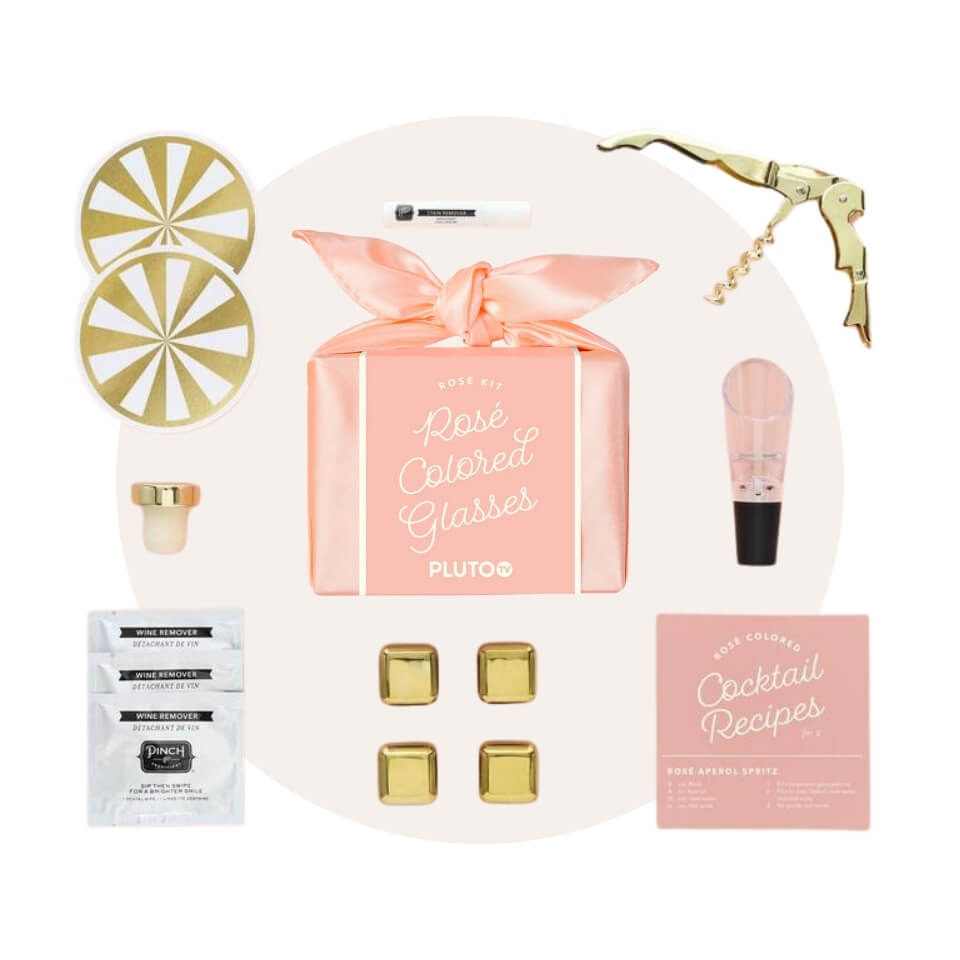 A pink silk box and various pink-and-gold wine accessories over a cream-coloured circle