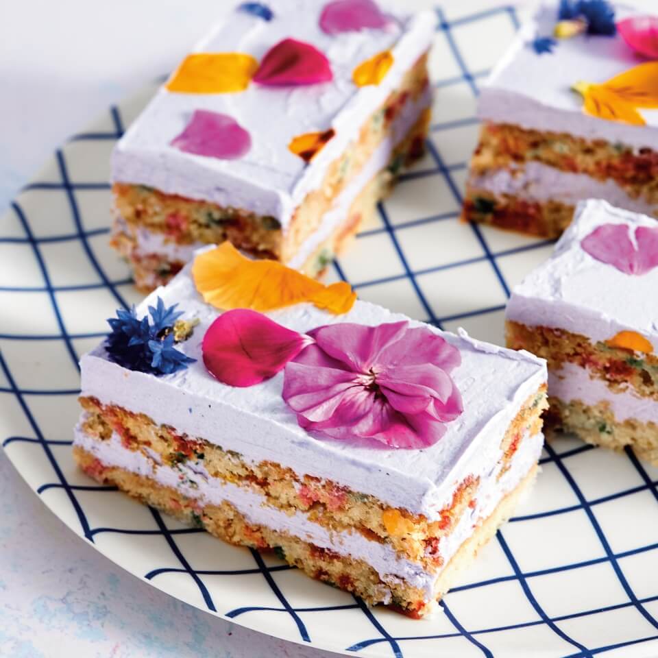 Dessert bars with pressed flowers in the frosting on a plate with a grid pattern