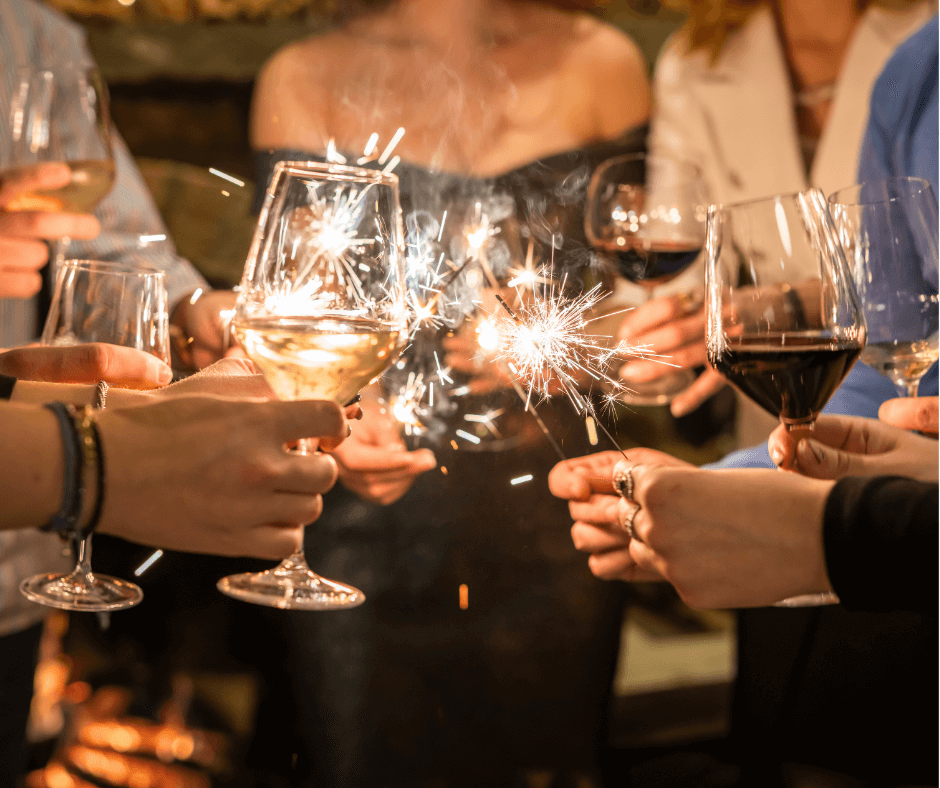 people holding glasses of wine with sparklers