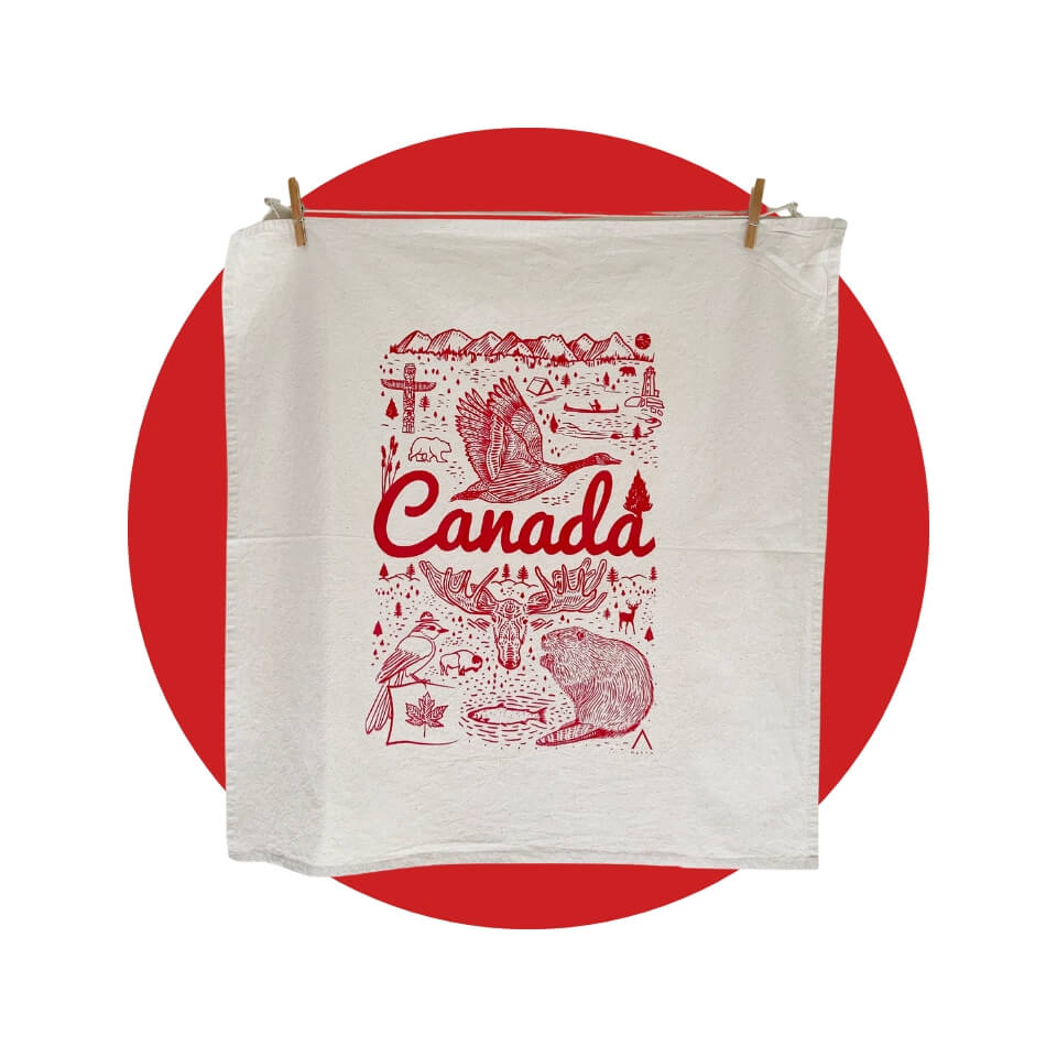 A white towel with the word "Canada" and a Canadian-themed design over a red circle