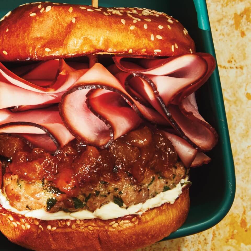A close-up of a burger with ham