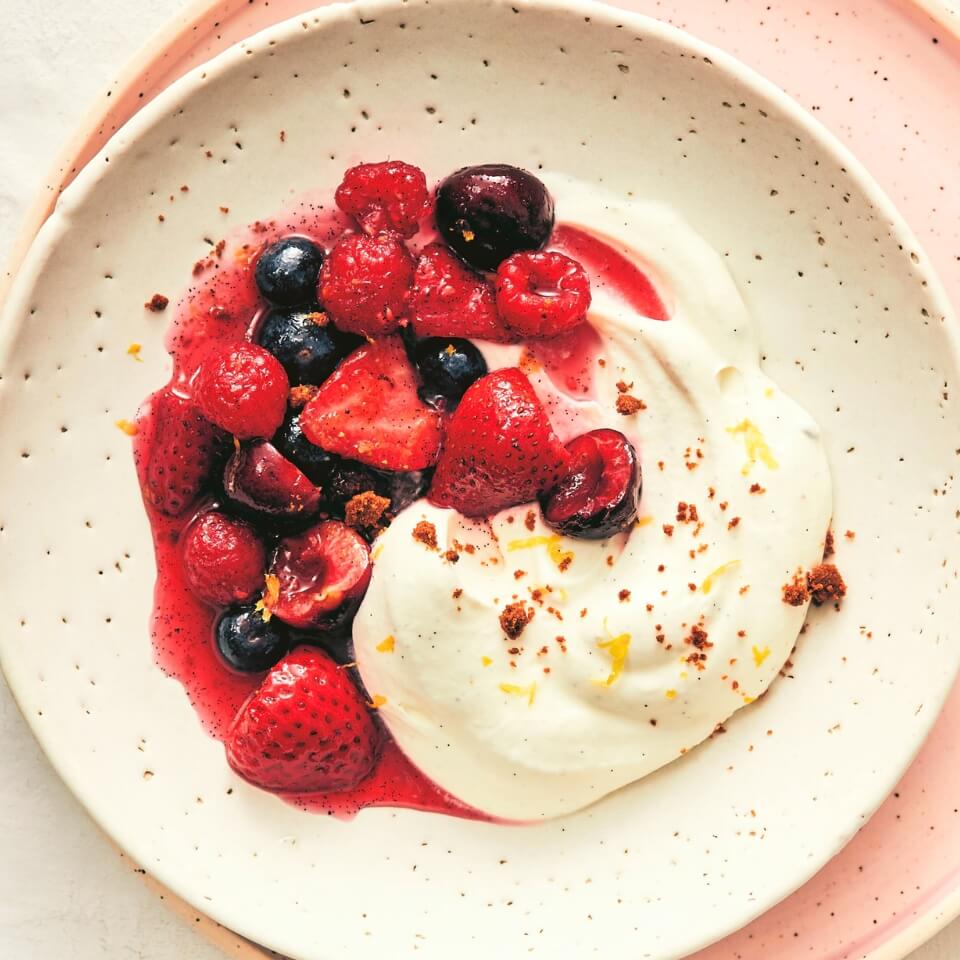 A bowl with whipped cream and berries