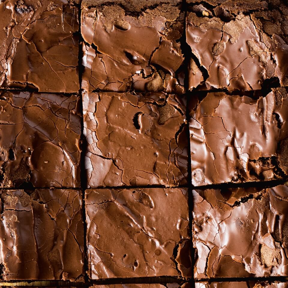 A closeup of chocolate brownies in a pan sliced into squares