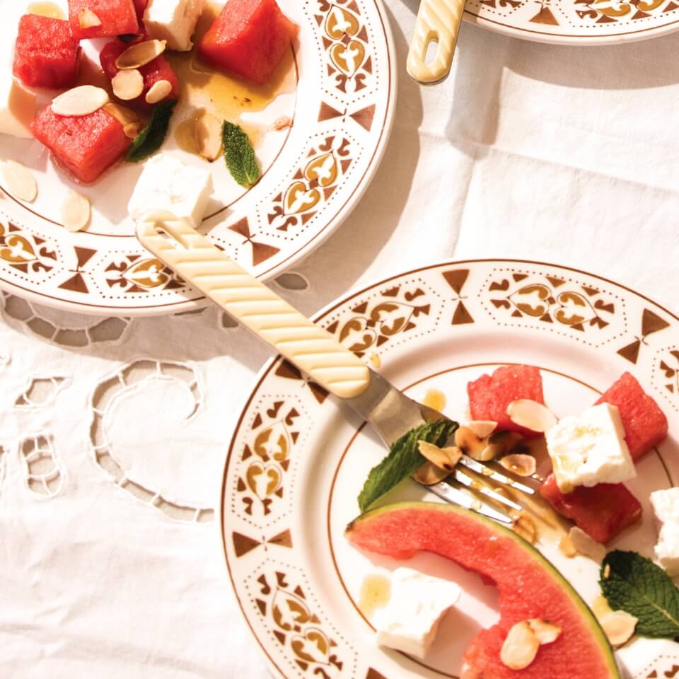 Plates of watermelon and feta salad on a white tablecloth