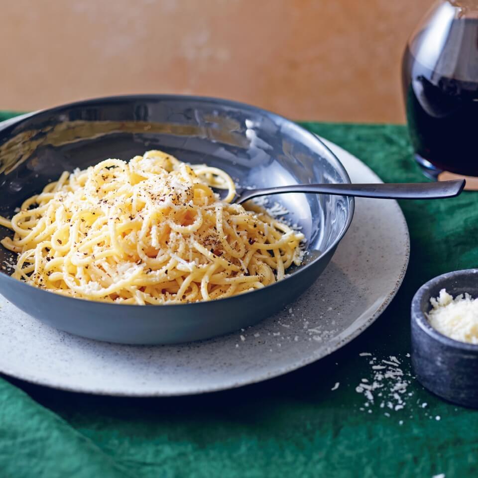 A blue dish with cacio e pepe on a plate