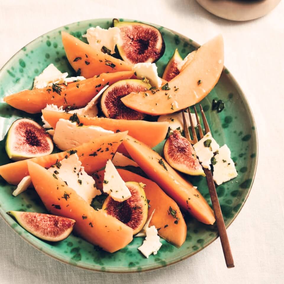 A dish with canteloupe, fig and feta cheese salad