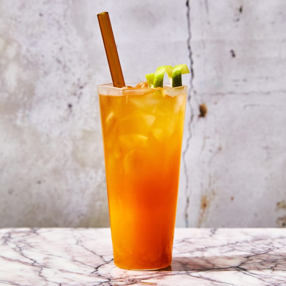 An orange drink with a straw