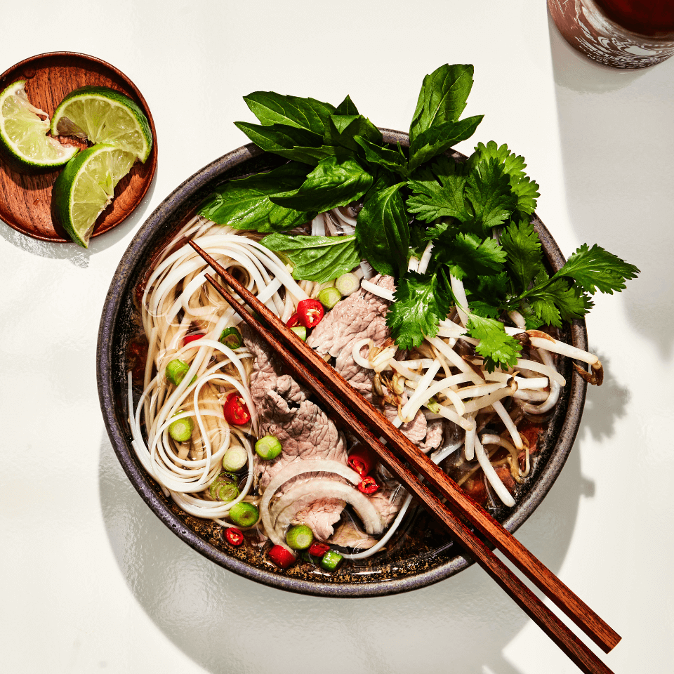 overhead image of noodle soup with chopsticks