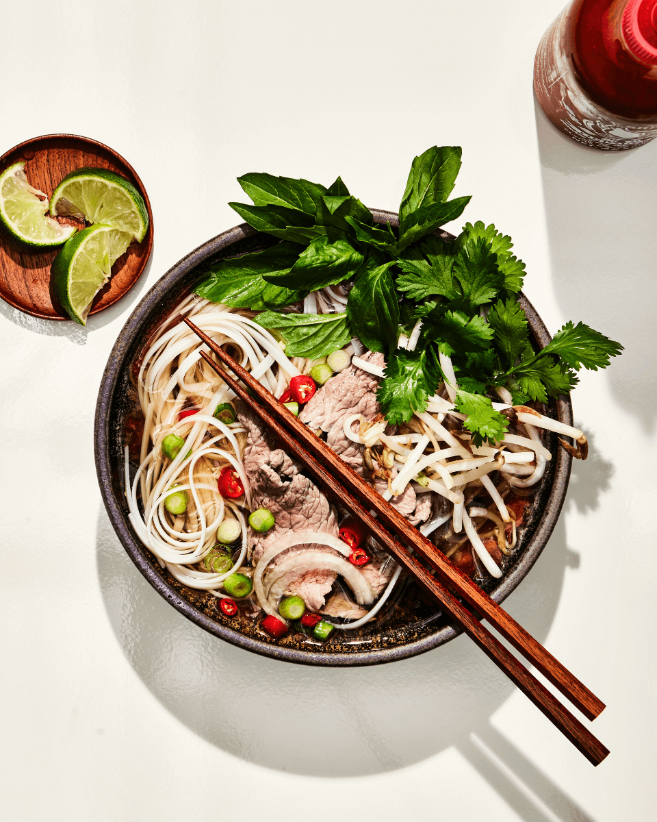 overhead image of noodle soup with chopsticks