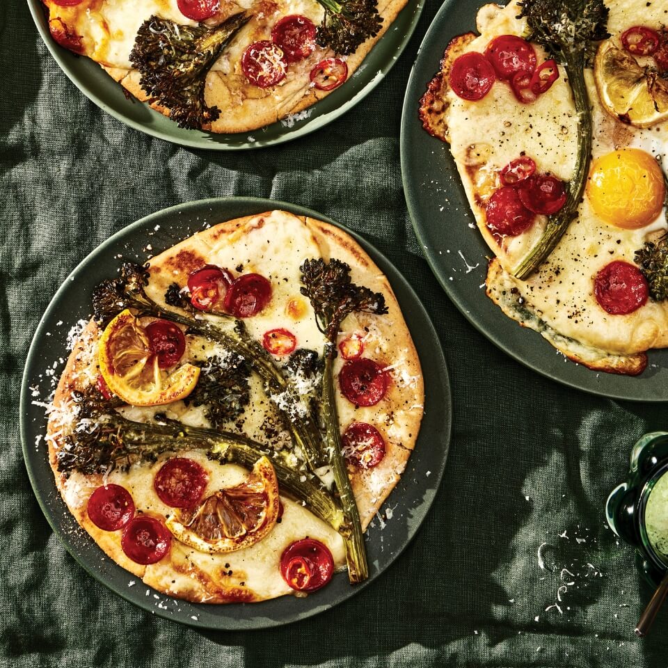 Broccolini and cherry tomatoes on naan bread pizzas