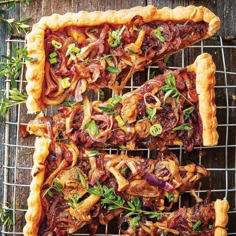 A mushroom and caramelized onion tart on a cooling rack
