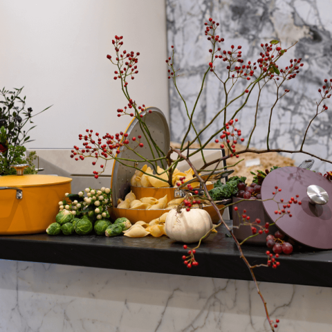 Various pots, pans and autumnal produce in a decorative display
