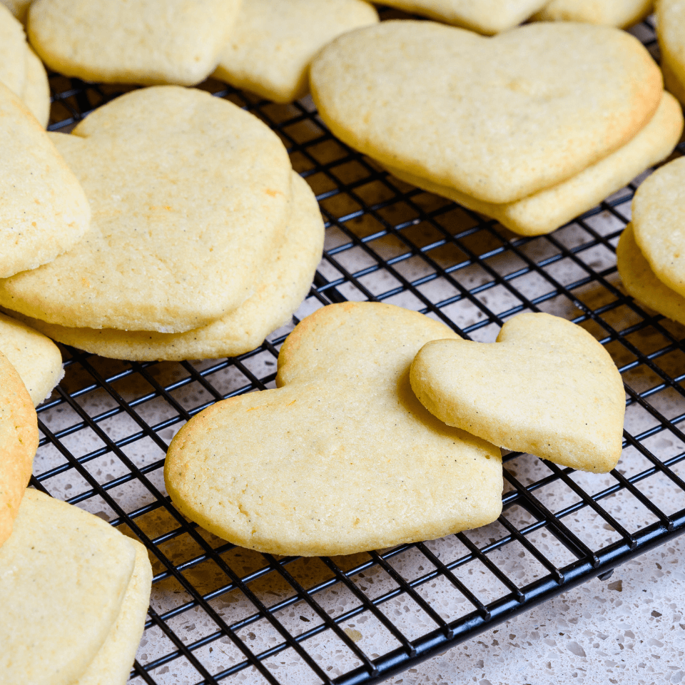 cooling rack of heart-shaped sugar cookies