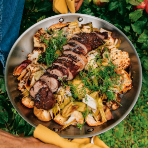 pan of pork tenderloin sitting on roasted vegetables