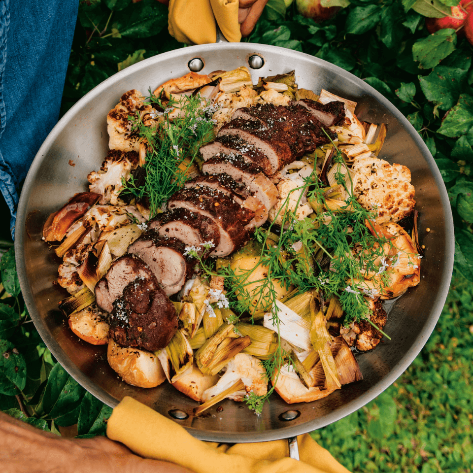 pan of pork tenderloin sitting on roasted vegetables