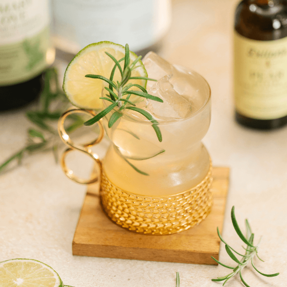 glass with cocktail and lime and rosemary