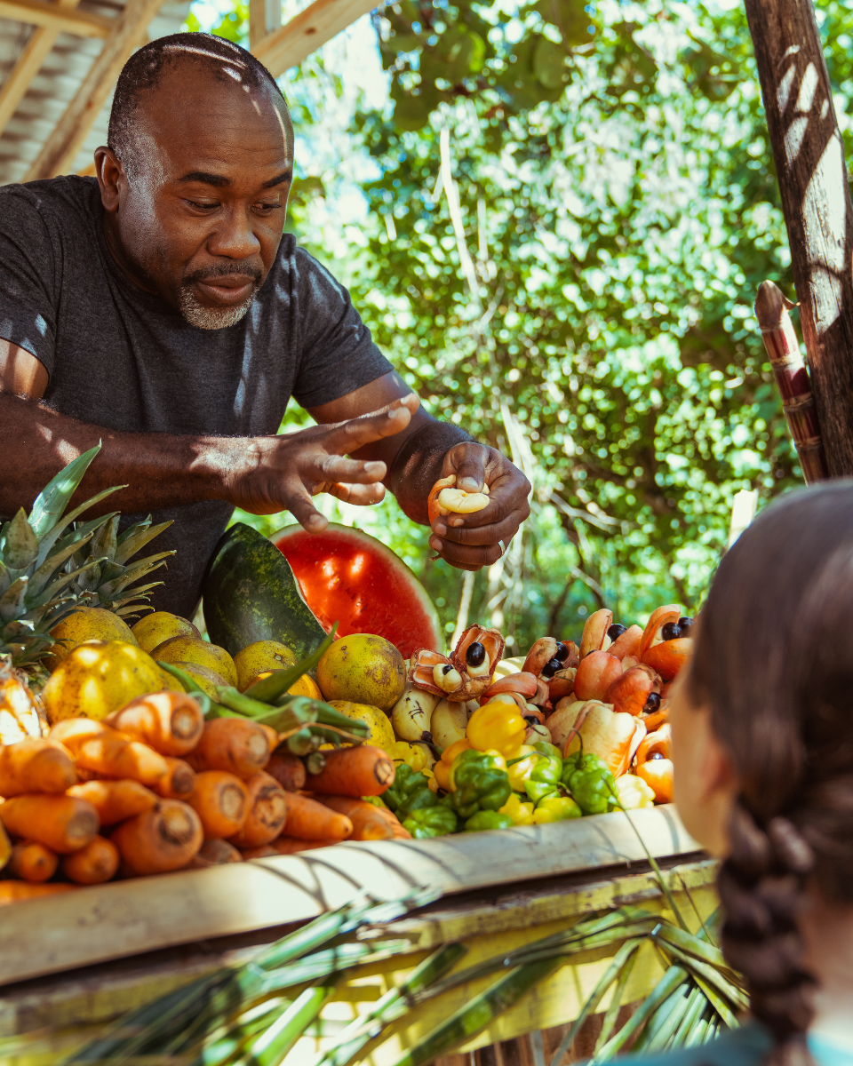 Man selling fruit at a roadside stand in Jamaica